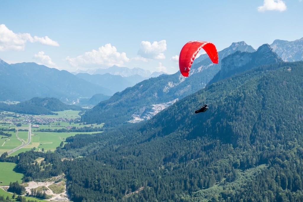 Verkehr am Himmel über Pfronten: Ein Solo-Paraglider fliegt neben dem Autoren und seinem Tandempiloten in Richtung Tal.