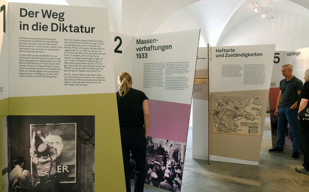 Frauen und Männer stehen im Schloss Colditz in der Wanderausstellung "Auftakt des Terrors- Frühe Konzentrationslager im Nationalsozialismus".