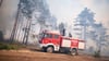 Einsatzkräfte der Feuerwehr bekämpfen in einem Waldstück nahe Jüterbog das Feuer.