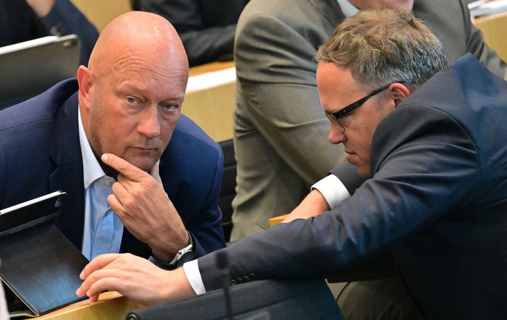 Thomas Kemmerich (FDP, l), Gruppensprecher, und und Mario Voigt (CDU), Fraktionsvorsitzender, unterhalten sich im Plenarsaal des Thüringer Landtags.