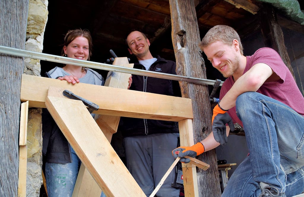 Sie lernen viel in der Praxis: Die Studenten Leona Vierling (von links), Karsten Bruch und Alexander Heyen bauen eine neue Strebe aus Holz im Zwerchhaus des Fleischhofes ein.