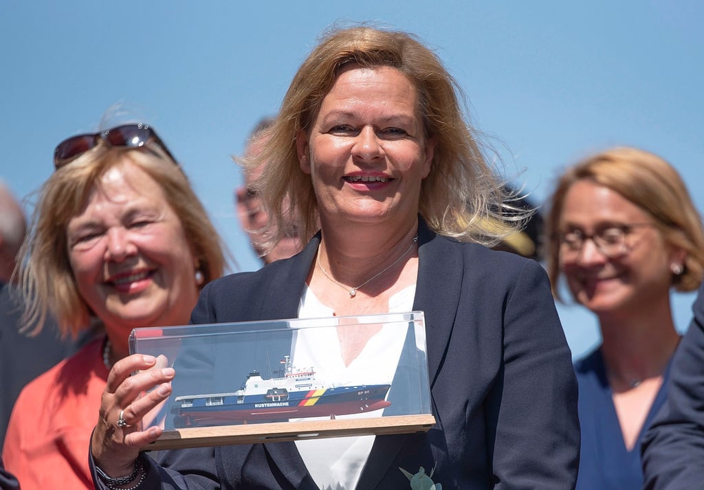 Bundesinnenministerin Nancy Faeser (SPD) hält nach der Taufe des Bundespolizeischiffs ein Modell davon in der Hand.