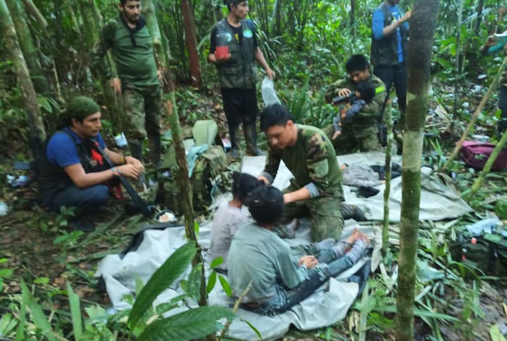 Soldaten und indigene Männer kümmern sich um die vier Geschwister, die nach dem Flugzeugabsturz vermisst wurden.