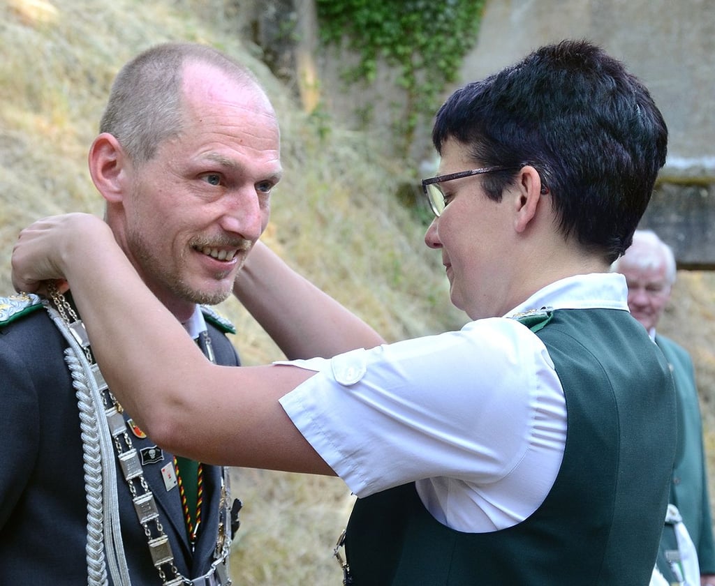 Gildevorsitzende Doreen Prox kleidet ihren Stellvertreter André Querfurth mit allem ein, was zu einem Schützenkönig gehört.