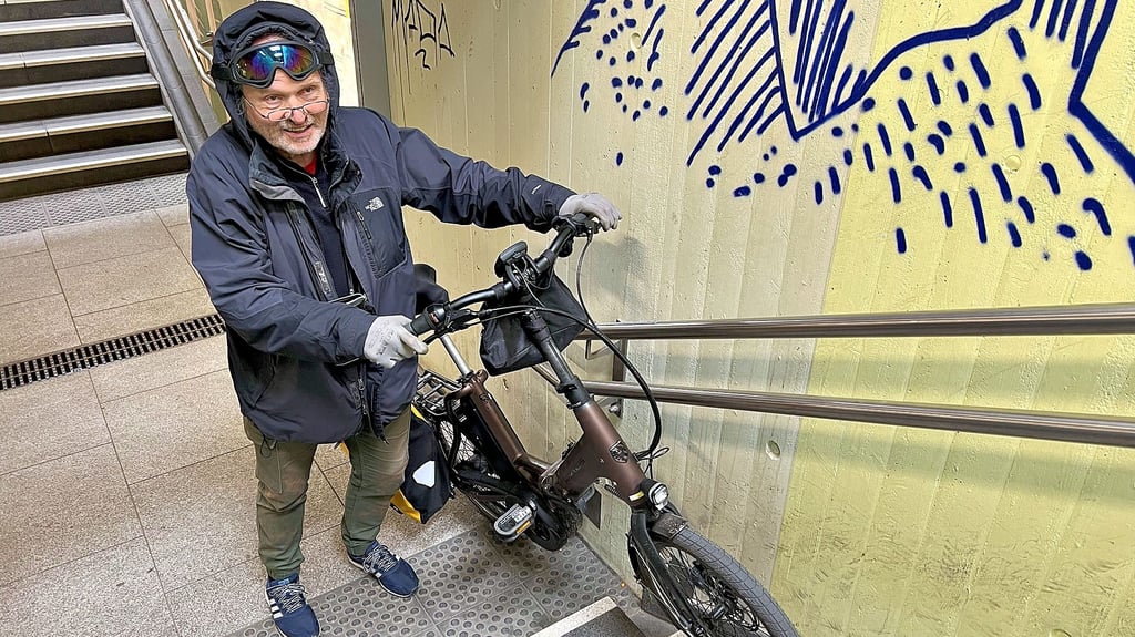 Die Rinnen parallel der Treppen im Hauptbahnhof Stendal sollen der Fahrradmitnahme dienen. Aber mit einem handelsüblichen Fahrrad kommt man kaum darunter, wie es hier ein Reisender aus Berlin demonstriert.