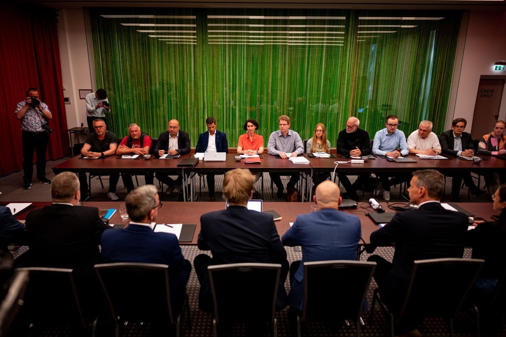 Vertreter der Deutschen Bahn (vorne) und der Eisenbahn- und Verkehrsgewerkschaft EVG sitzen am Verhandlungstisch in Berlin.