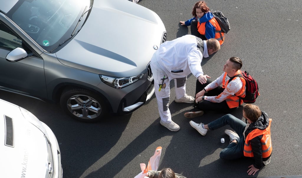 Ein Mann redet bei einer Blockade der Gruppe Letzte Generation auf der Stadtautobahn A100 unweit des Kurfürstendamms auf Aktivisten ein.