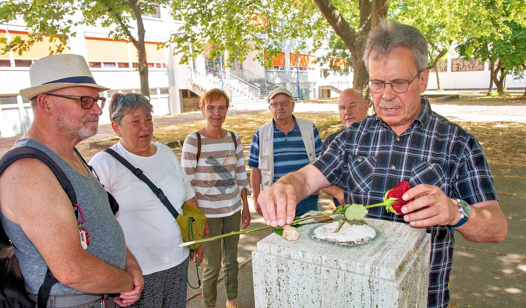 Vertreter des Stadtverbandes Dessau der Linken legen auf dem nun leeren Sockel eine Rose nieder.