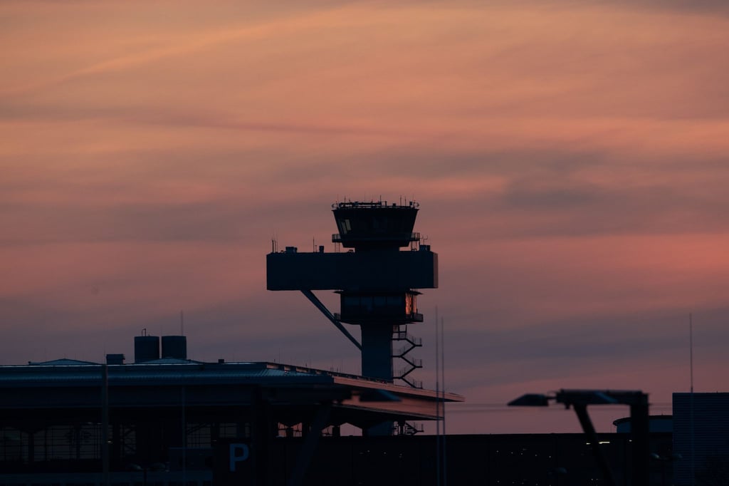Der Tower des Hauptstadtflughafens BER vor rotem Abendhimmel.