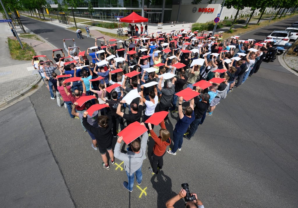Bosch-Mitarbeiter stehen bei einer Kundgebung vor dem Bosch-Halbleiter-Werk.