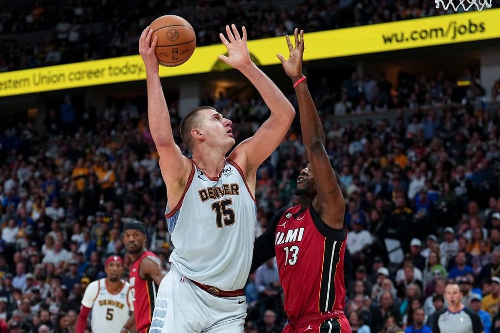 Denver Nuggets-Center Nikola Jokic (15) wirft über Miami Heat-Center Bam Adebayo.