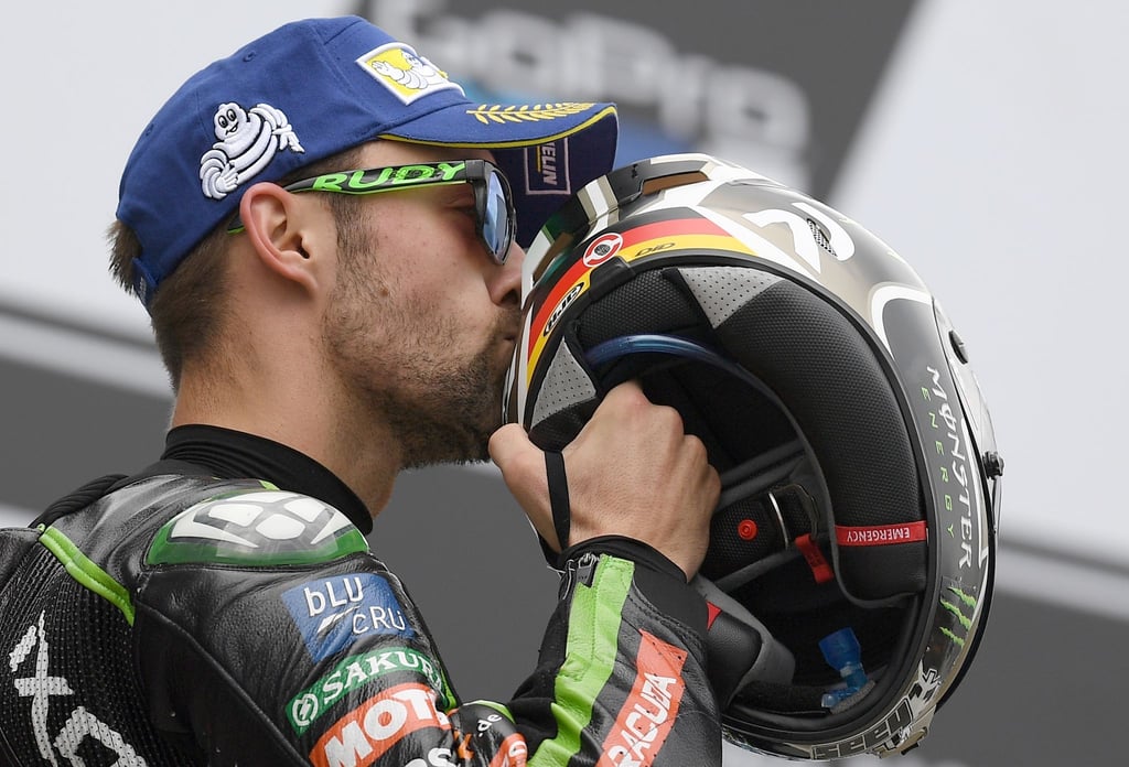 Der deutsche MotoGP Fahrer Jonas Folger vom Monster Yamaha Tech 3 Team freut sich über seinen zweiten Platz und küsst seinen Helm.