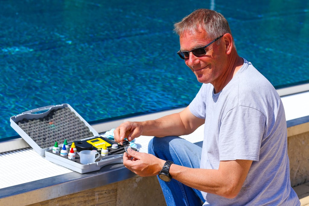 Schwimmmeister Olaf Tobisch führt eine Beckenanalyse durch und entimmt eine Wasserprobe.