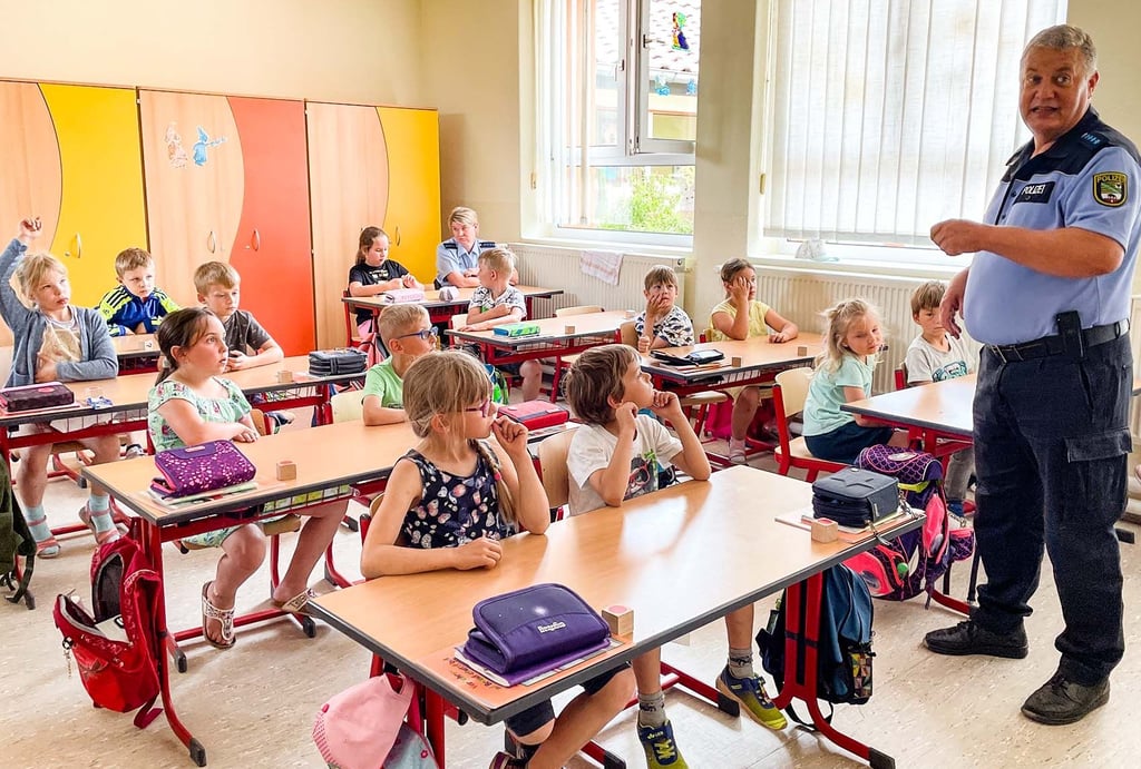 Die Regionalbereichsbeamten Lutz Pelzer und Anja Andres (hinten) kamen mit den Schülern der Schlagenthiner Grundschule zum Thema Kokeln ins Gespräch.