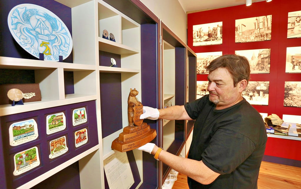 Steffen Aßmann räumt die Bernburg-Souvenirs aus DDR-Zeiten in die Regale des Museums ein.