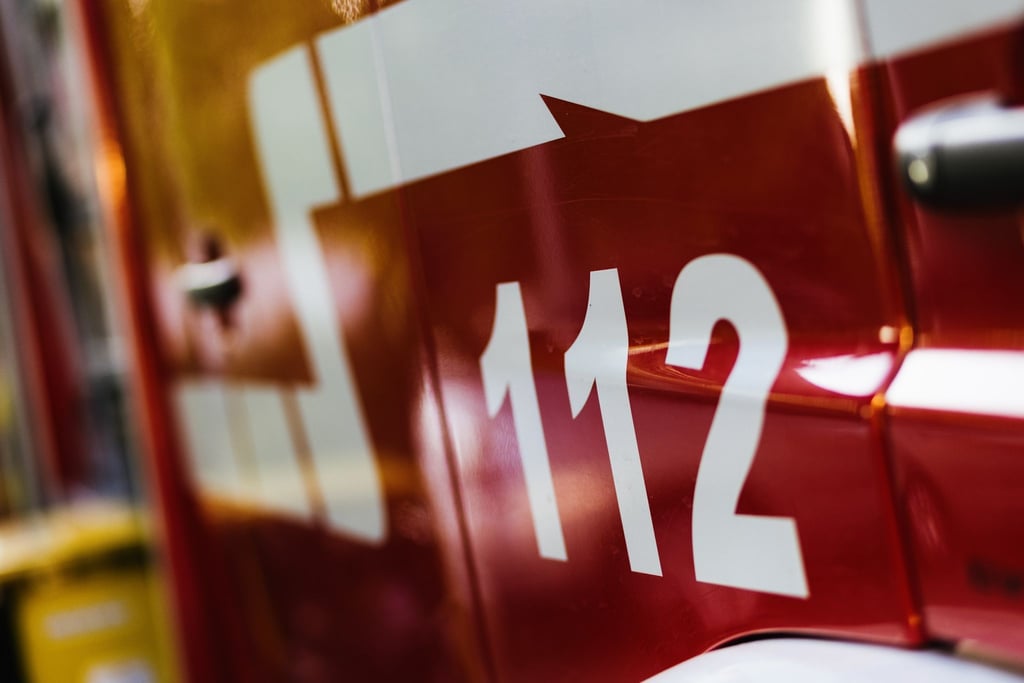 Ein Feuerwehrfahrzeug steht auf dem Hof eines Feuerwehrgerätehauses.