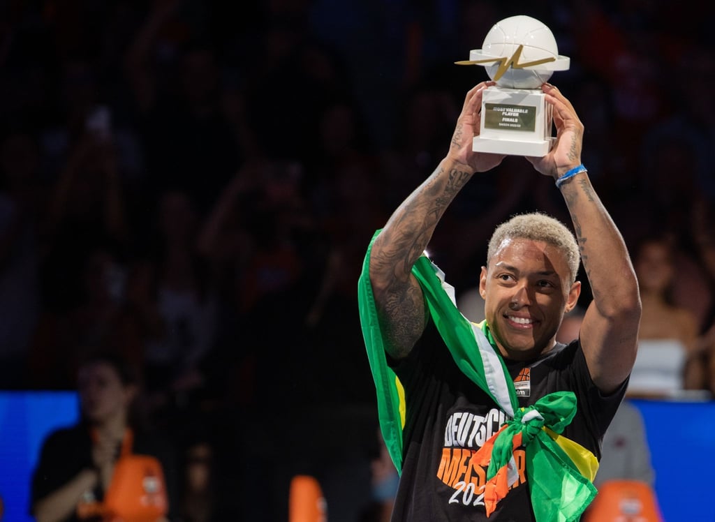 Ulms Yago dos Santos reckt die Trophäe für den wertvollsten Spieler der Playoffs hoch.