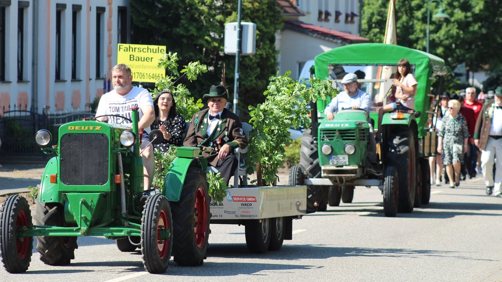 Mit kleinen Traktoren wurden die neuen Majestäten zum Schützenhaus chauffiert. Befreundete Schützen und Vereine sowie viele Bürger liefen im Umzug mit.