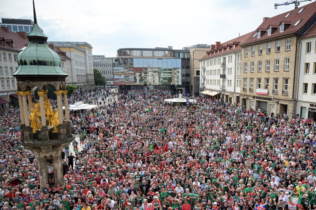 Fans warten auf dem Markt auf den Auftritt der Mannschaft.