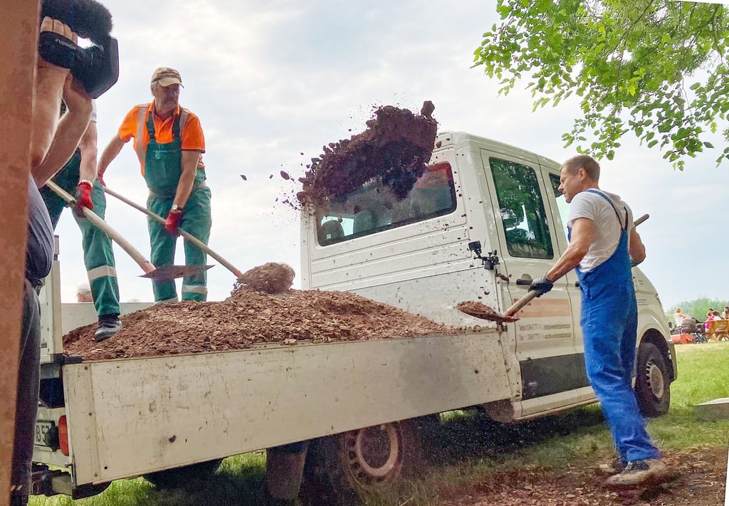 Zunächst schaufeln die Männer das Material für das Fundament von der Ladefläche.