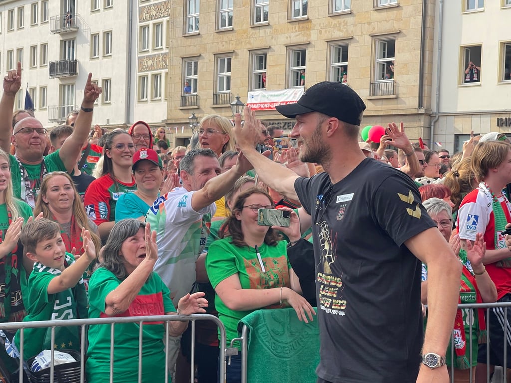 Nach dem Gewinn der Handball-Champions-League strömen die SCM-Fans zum Rathaus in Magdeburg, um ihre Helden zu bejubeln. Hier geht SCM-Rückraum-Spieler Philipp Weber auf Tuchfühlung mit den Fans.
