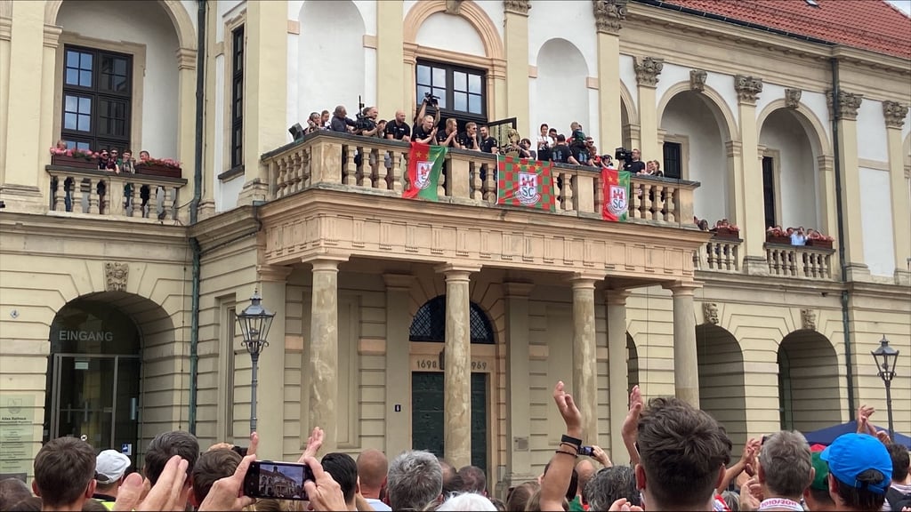 Die Handballer des SCM präsentieren sich in Magdeburg auf dem Rathaus-Balkon und feiern mit ihren Fans.