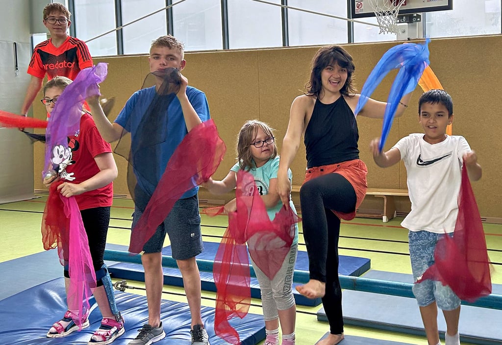 Mit bunten Tüchern zeigt eine Zirkuspädagogin an der Magdeburger Regenbogenschule den Kindern, wie sie ganz leicht einen Einstieg in das Jonglieren finden.