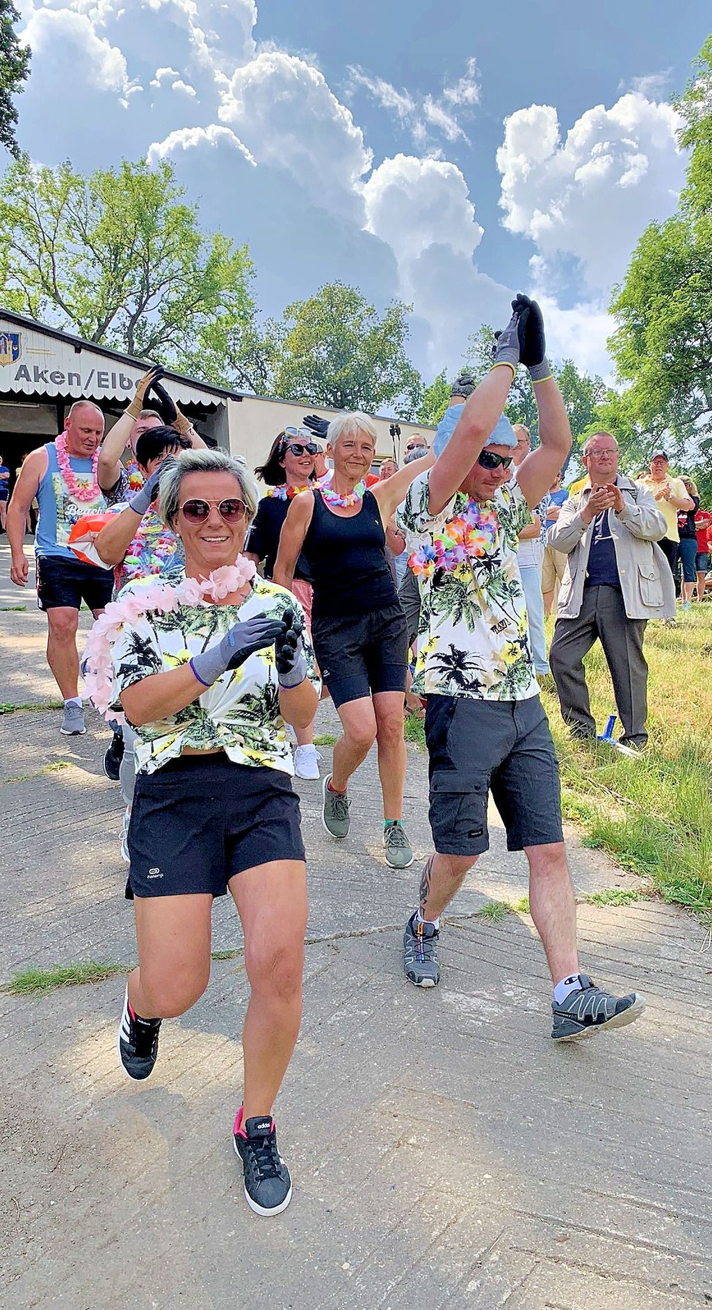 Das Team „Trockenschwimmer“ ist am Bootshaus des Ruder-Clubs in Aken auf dem Weg zum Kutter am Ufer der Elbe.