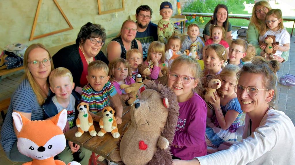 Stolz präsentieren Kinder, Mütter und Erzieher ihre selbstgenähten Stofftiere. Füchsin Lissy und Igel Til sind die neuen Maskottchen der Gruppen in der Tagesstätte Zwergenland in Erxleben. Zu den Organisatorinnen zählt Saskia Fröhlich (r.) vom Förderverein.