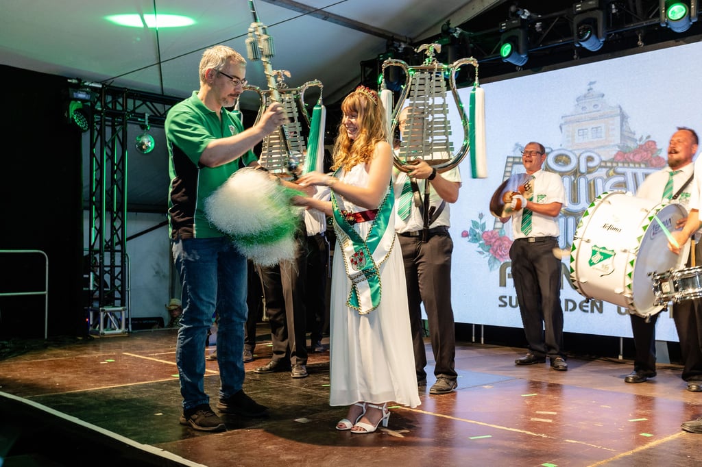 Wohl, weil er auch mit den Pompons wedeln will: Bürgermeister Stefan Schmidt gibt das Zepter an die Rosenprinzessin Emma Ihrke ab.