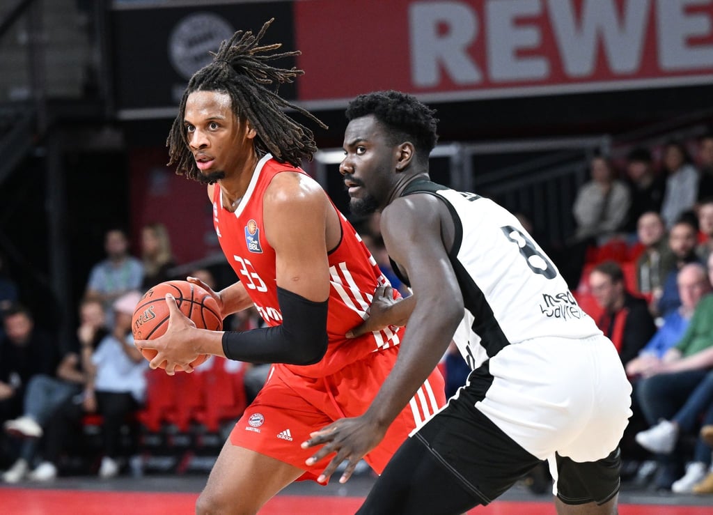 Freddie Gillespie (l) von München und Nat Diallo kämpfen um den Ball.
