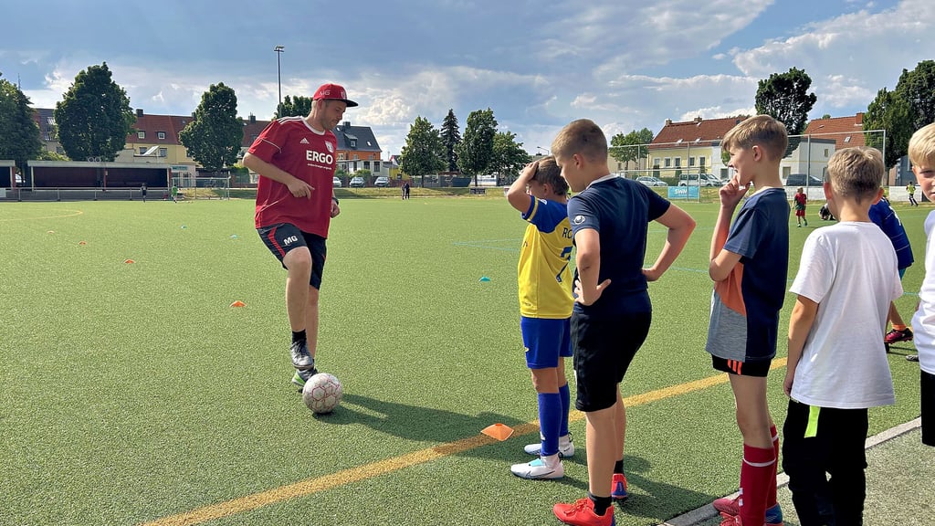 Nachwuchsleiter und Trainer im Magdeburger Verein Germania Olvenstedt, Markus Goldmann, zeigt den Neun- und Zehnjährigen auf dem Sportplatz eine Übung zum Aufwärmen.