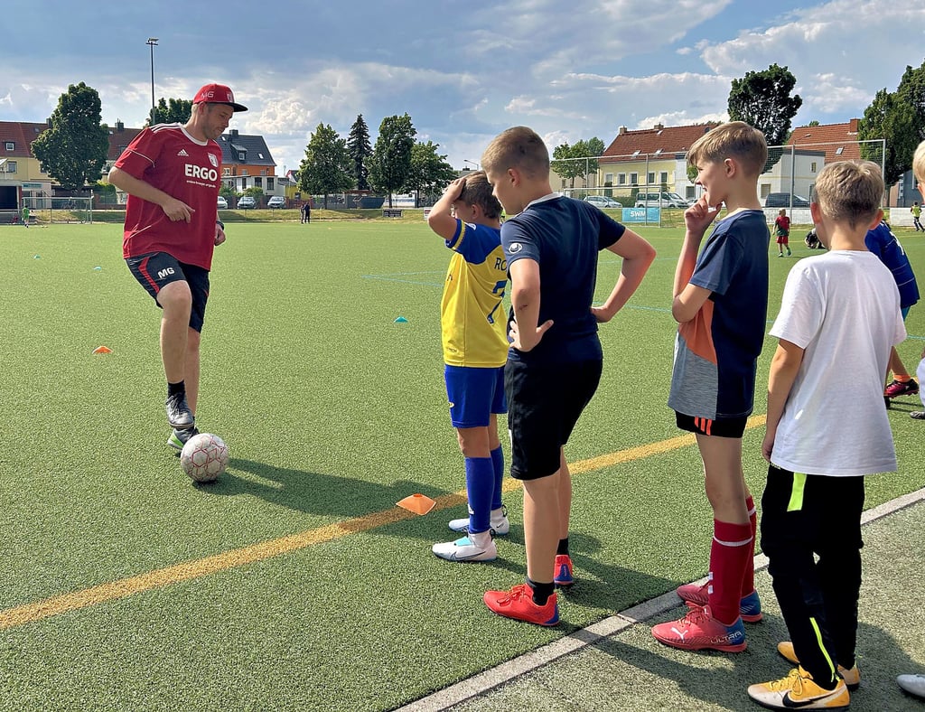 Nachwuchsleiter und Trainer im Magdeburger Verein Germania Olvenstedt, Markus Goldmann, zeigt den Neun- und Zehnjährigen auf dem Sportplatz eine Übung zum Aufwärmen.