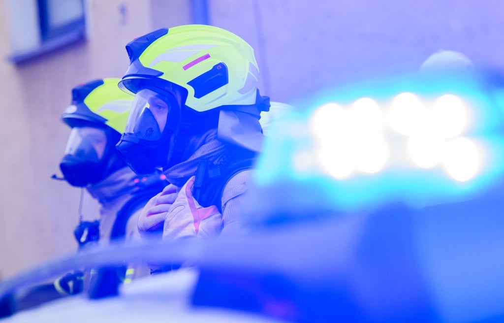 Feuerwehrleute stehen an einem Einsatzort.