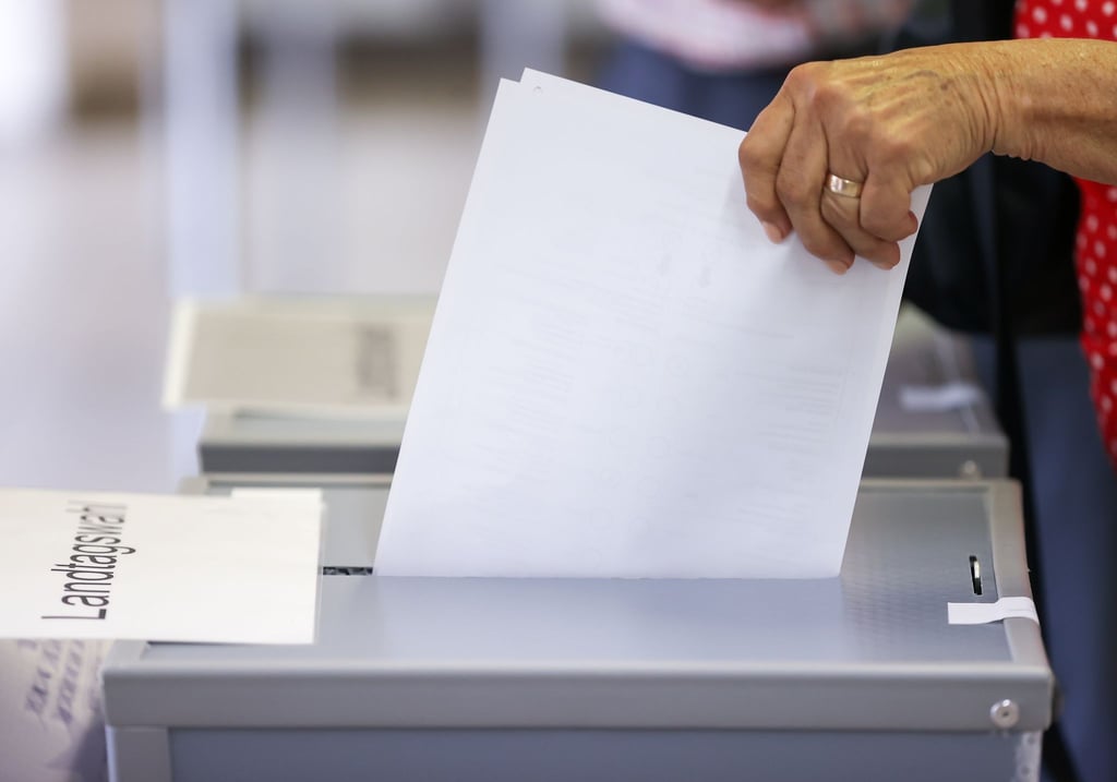 Eine Frau wirft ihren Stimmzettel in eine Urne in einem Wahllokal.