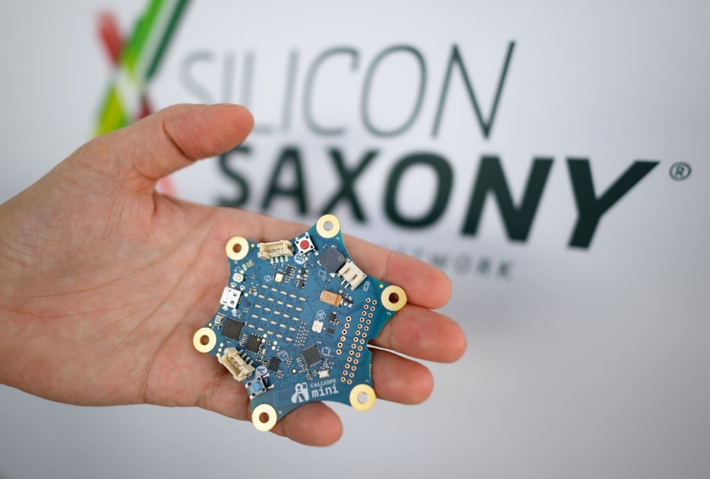 Ein Mitarbeiter hält die Platine „Calliope mini“ für Programmierübungen.