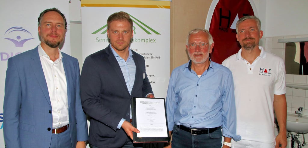 Kristian Koch, Leiter des Geschäftsbereichs Arztpraxen und Krankenhaus und bei Medicover (v. l.), Florian Dietrich, Geschäftsführer des Saale-Krankenhauses in Calbe zeigt den neuen Vertrag mit Dr. Burkhard John, Geschäftsführer des AGR Senioren Rehakomplexes und Dr. med. Robin John, Geschäftsführer des MVZ Hausarztteams, nach der Unterzeichnung in Calbe.