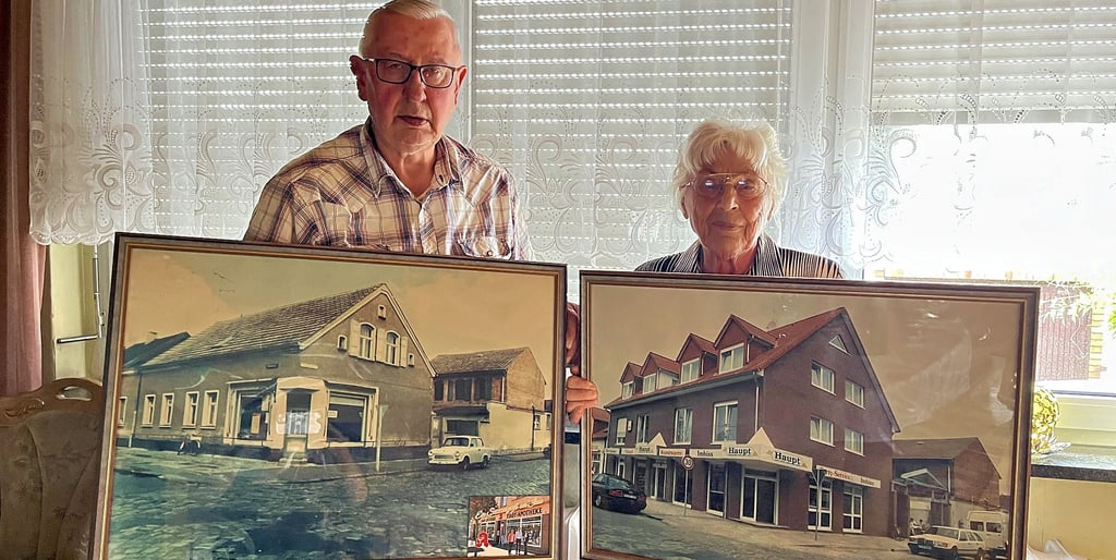 Wolfgang und Gerda Haupt aus Tangerhütte mit Aufnahmen ihres Geschäftes aus den 60er Jahren (links) und nach dem Neubau 1993 (rechts). Eigentlich stammen beide aus der Lausitz, konnten dort zu DDR-Zeiten aber kein eigenes Geschäft eröffnen.