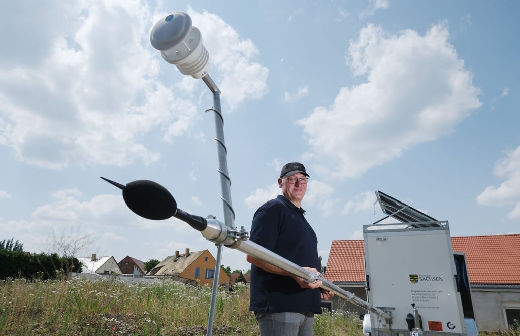 Jörg Puchmüller, Fluglärmschutzbeauftragter des Landes Sachsen, hält den Mast einer mobilen Messstation für Fluglärm.