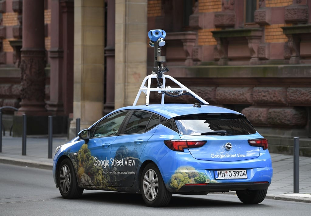 Mit einer auffälligen Kamera auf dem Dach fährt ein Auto von Google Street-View durch das Gerichtsviertel in Frankfurt.