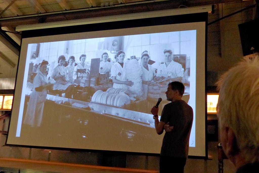 Museumsleiter Sven Sachenbacher (im Vordergrund) fragte die Gäste nach den Inhalten der Bilder. Hier ist die Hygieneartikelproduktion zu sehen.