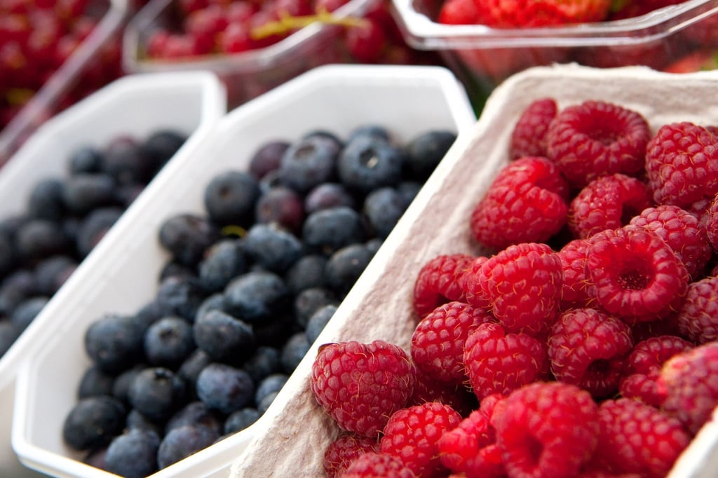 Enthalten unter anderem Vitamin C: Heidelbeeren und Himbeeren sollten beim Kauf in der Schale schön prall sein. Zu Hause lagert man sie flach drapiert und kühl.