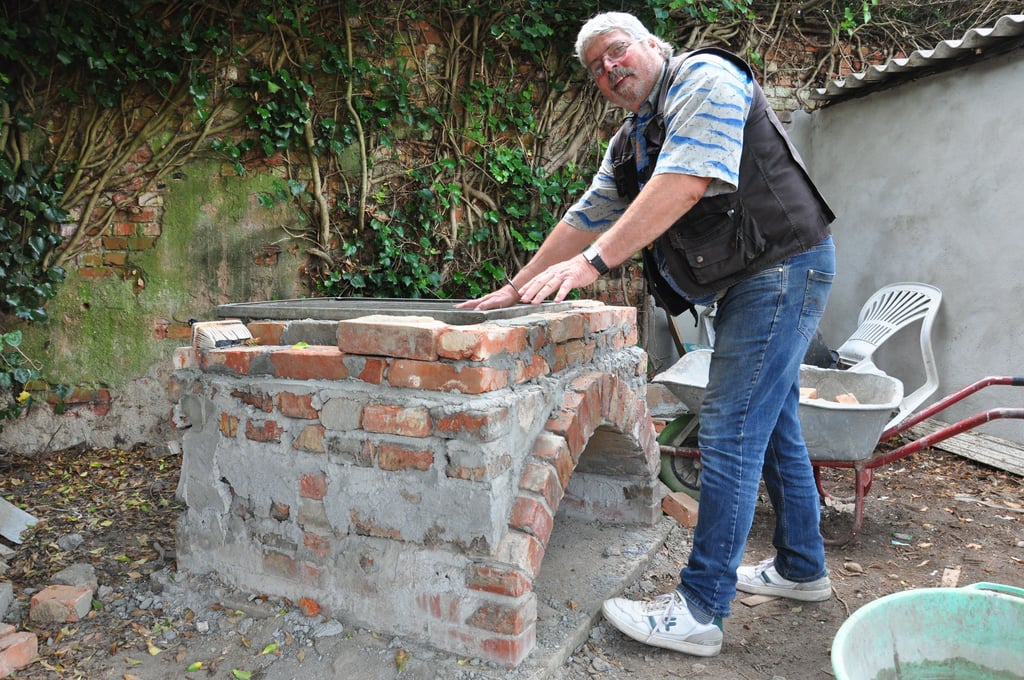 Gerade ist er nicht künstlerisch, sondern handwerklich tätig: Peter Clauss baut, abwechselnd mit anderen, an einem Pizza-Ofen für den Verein Künstlerstadt Kalbe.