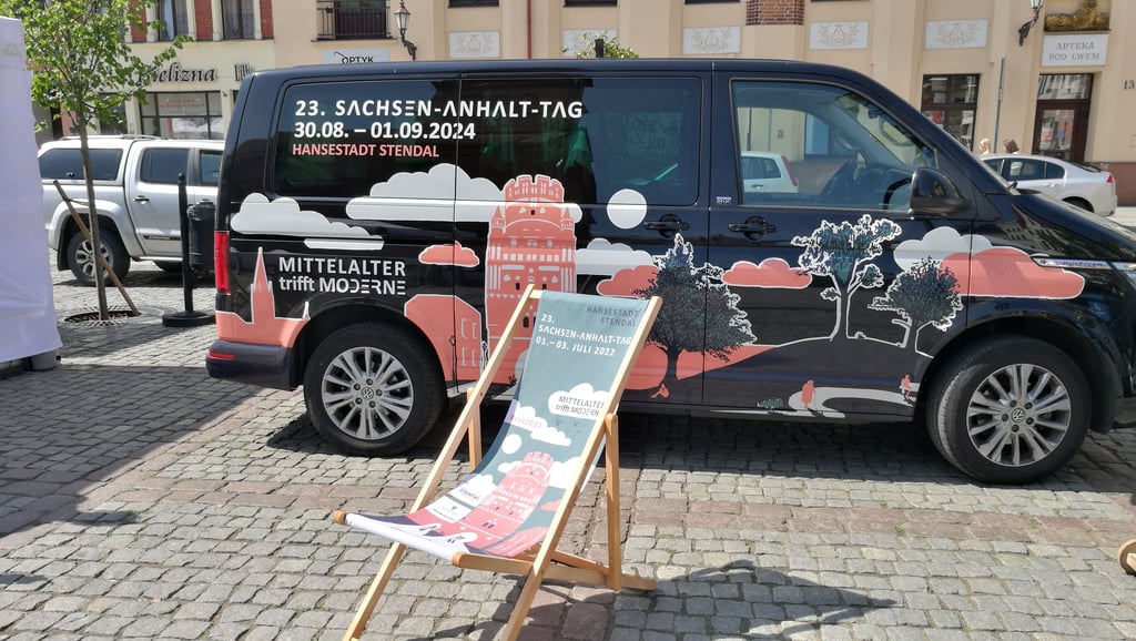 Die Hansestadt Stendal wirbt auf dem Internationalen Hansetag im polnischen Torun für den Sachsen-Anhalt-Tag 2024 in Stendal. Liegestuhl und Fahrzeug zeigen Motto und das offizielle Werbemotiv für das Landesfest.
