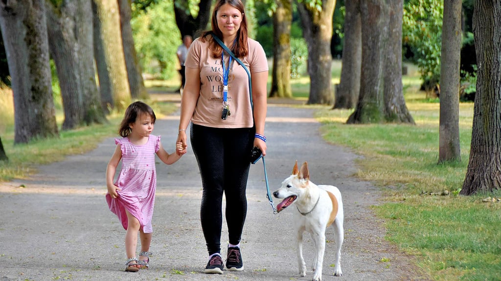 Sandy Espig und ihre dreijährige Tochter Aria spazieren mit Murphy durch die Parkanlage am Dämmchen in Oebisfelde. Die Hundehalterin hat Tüten für Hinterlassenschaften ihres Vierbeiners dabei.