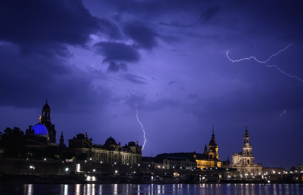 Blitze entladen sich während eines Gewitters am Abend über der Altstadt an der Elbe.
