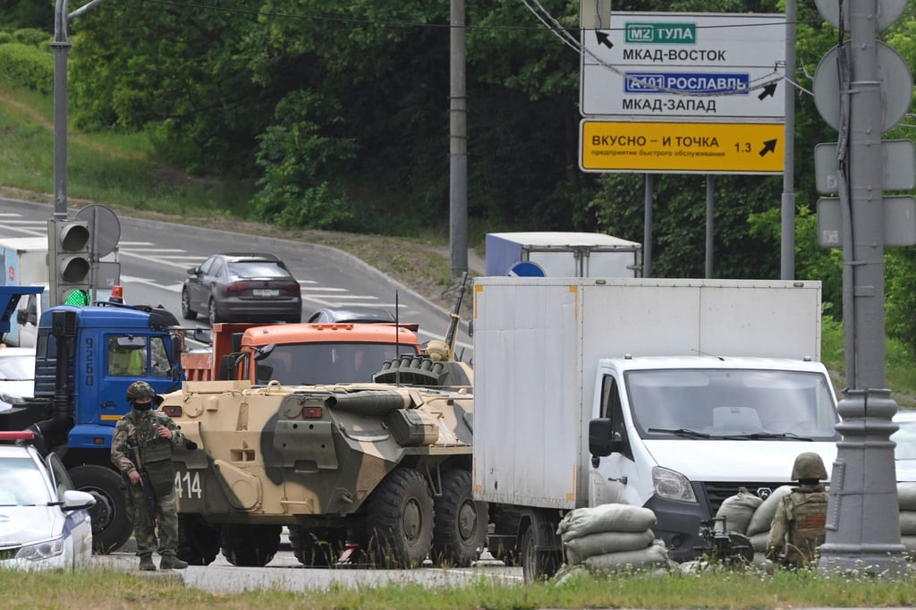 Russische Armeeangehörige bewachen die Autobahn bei Moskau mit einem Mannschaftstransportwagen.
