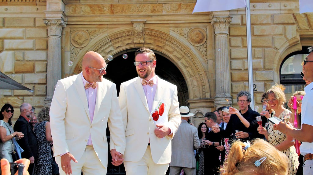 Wolfgang und Sebastian Aldag werden nach der Hochzeit vor dem Stadthaus in Halle empfangen.
