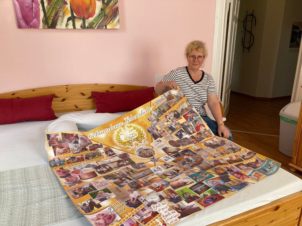 Lauter Erinnerungen: Zum 25-jährigen Bestehen ihres Geburtshauses hat Nicolle Scheibel-Hellfritsch ein großes Plakat mit Fotos von Kindern und Eltern, die sie betreut hat, anfertigen lassen.