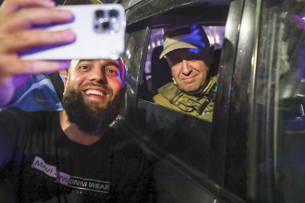 Jewgeni Prigoschin (r), Eigentümer des Militärunternehmens Wagner Group, sitzt in einem Militärfahrzeug und lässt ein Selfie mit einem Zivilisten auf einer Straße in Rostow am Don machen.
